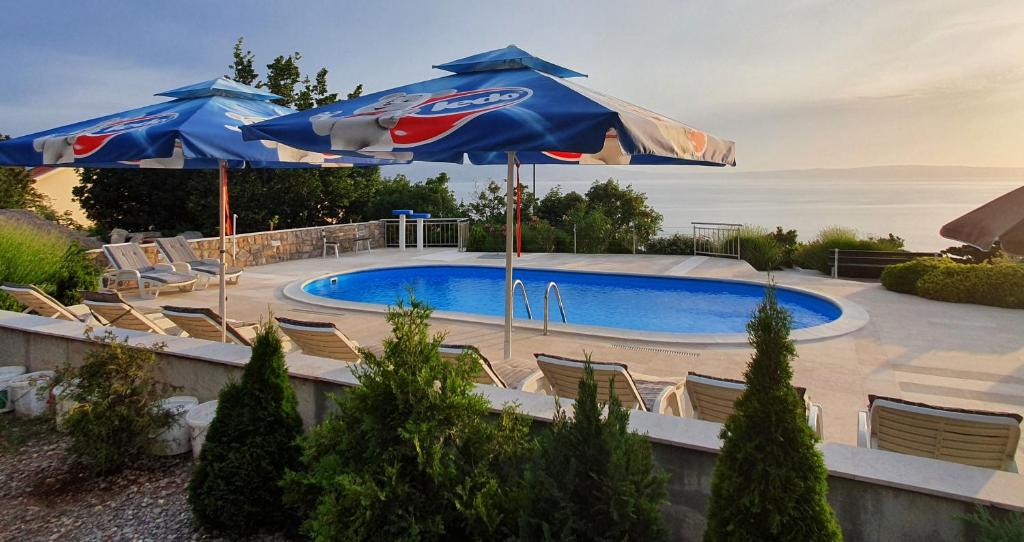 una piscina con sillas y sombrillas junto a una piscina en Apartments Marion Klenovica, en Klenovica