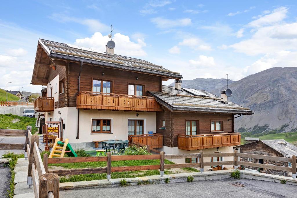 una casa con balconi in legno e recinzione di Appartamento Greta Baita Mauri a Livigno