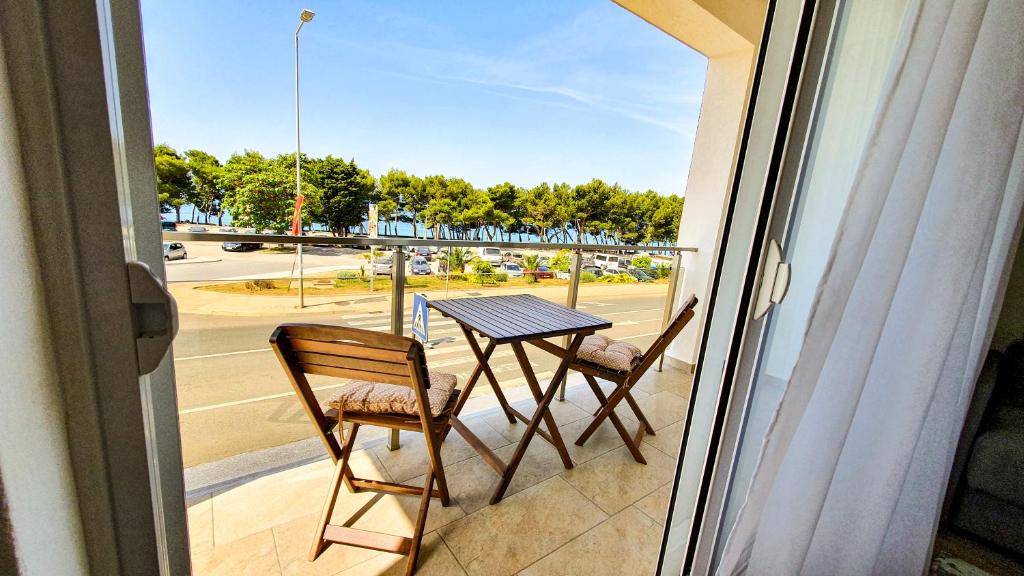 a table and chairs on a balcony with a view of a street at Olav Holiday Apartments Bar in Bar