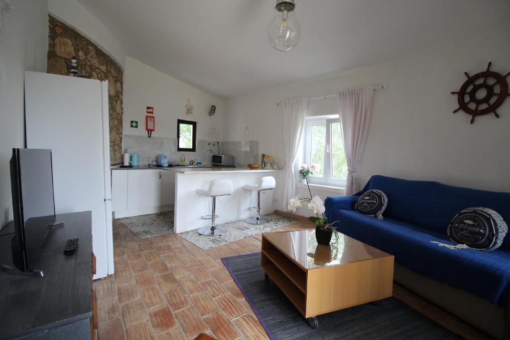 a living room with a blue couch and a table at Casa do Milho in Carvoeiro