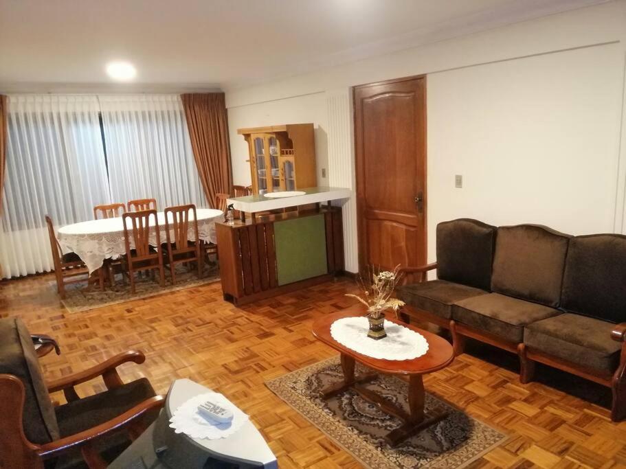 un soggiorno con un divano e un tavolo di Amplio departamento en la zona central norte 1B a Cochabamba