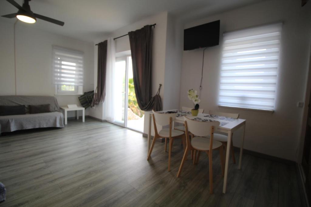 a living room with a table and chairs and a bedroom at Casa do Milho in Carvoeiro