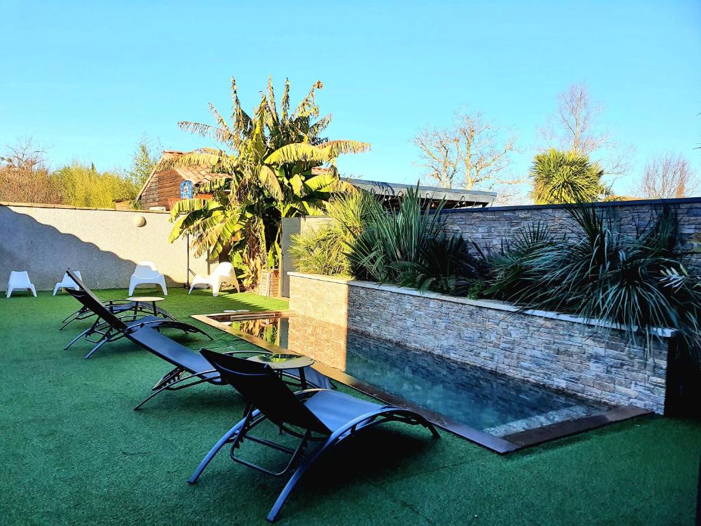 a group of chairs sitting next to a swimming pool at Les Granges de Jules in Lafitte-Vigordanne