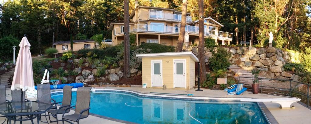 ein Haus mit einem Pool vor einem Haus in der Unterkunft Rae Leigh Heights BnB in Saanichton