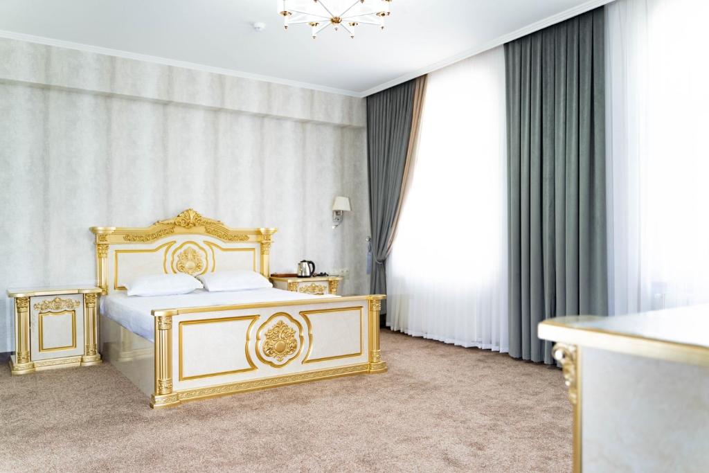 a bedroom with a gold bed and curtains at Reikartz Bahor Bukhara in Bukhara