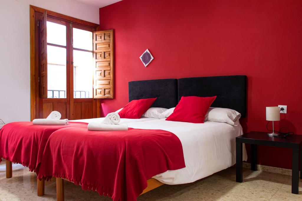 a red bedroom with a large bed with red walls at 1D Apartamento con vistas a la Alhambra in Granada