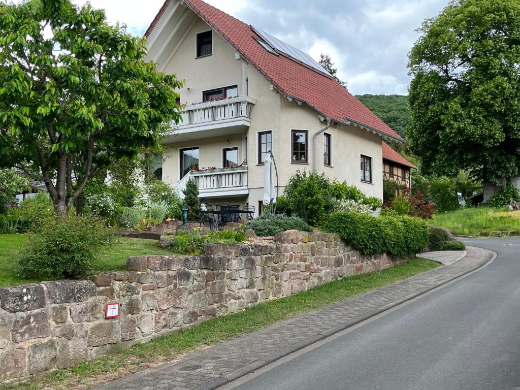 a house with a stone wall next to a road at Hirtenrasen 52A in Lindewerra