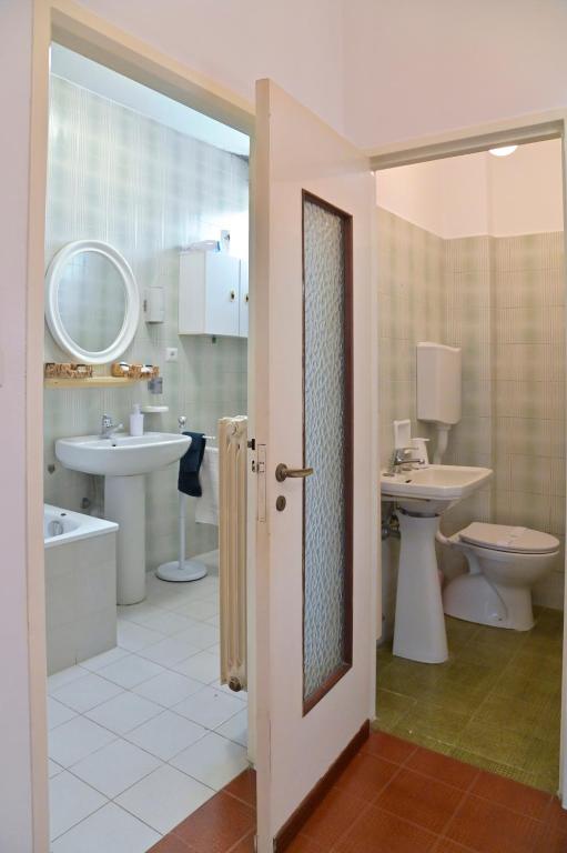 łazienka z 2 umywalkami, wanną i toaletą w obiekcie Casa Serena w mieście Ivrea