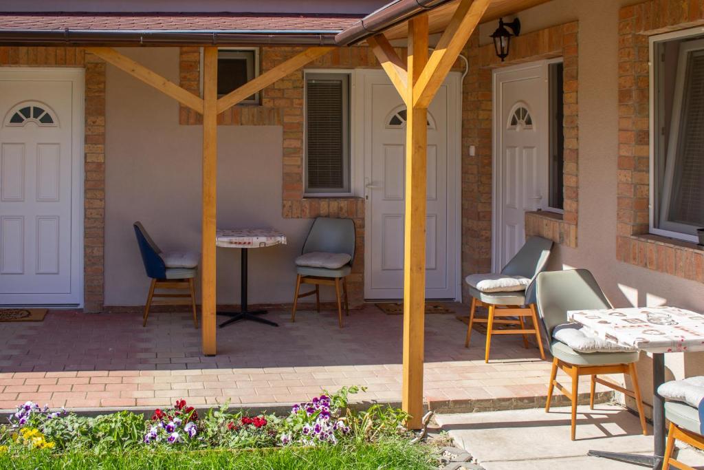 a patio with chairs and tables on a house at Ilona Apartman in Gyula