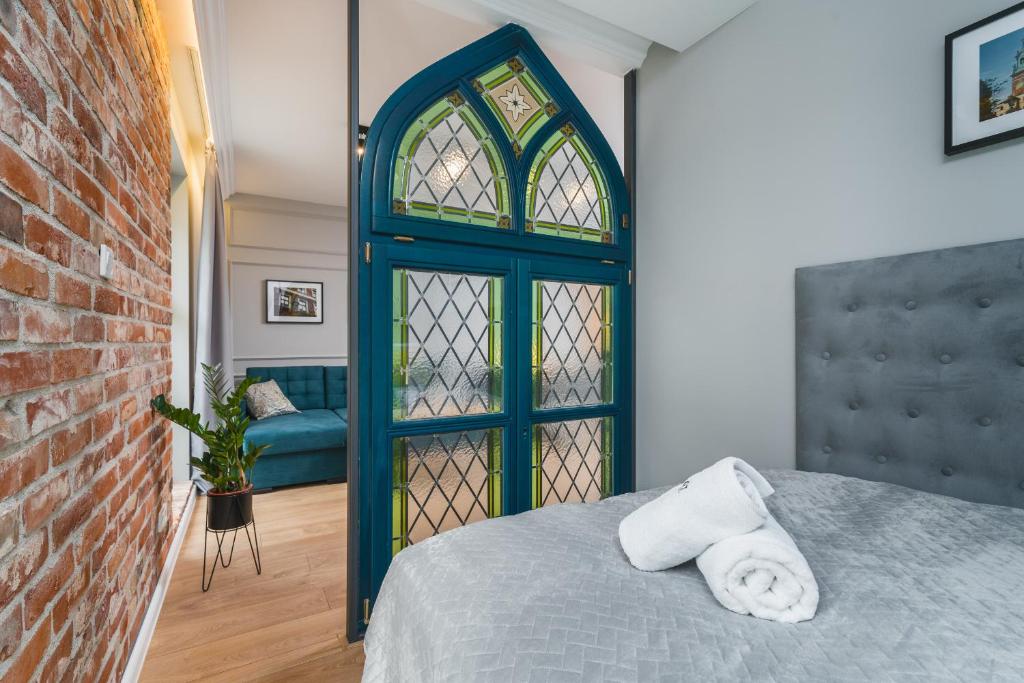 - une chambre avec une porte bleue et des serviettes sur un lit dans l'établissement Saint Florian's Suites - Old Town Luxury Apartments, à Cracovie