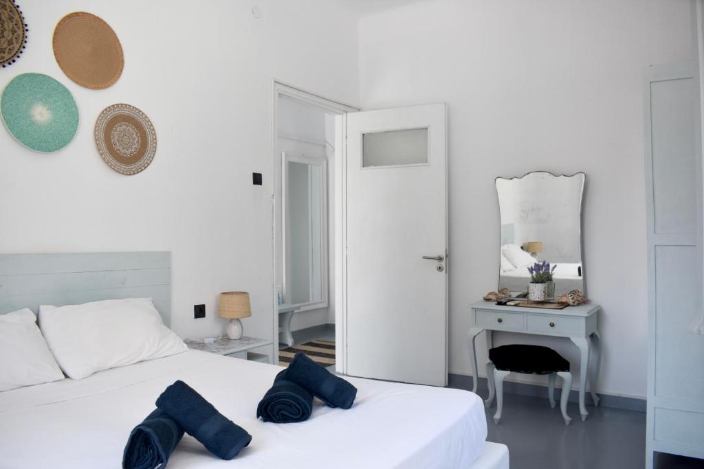 a white bedroom with two beds and a table at The Greek side of life! in Artemida