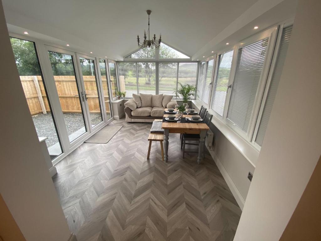 a living room with a table and a couch at Dolwen Snowdonia Home by PolkaDot in Caernarfon