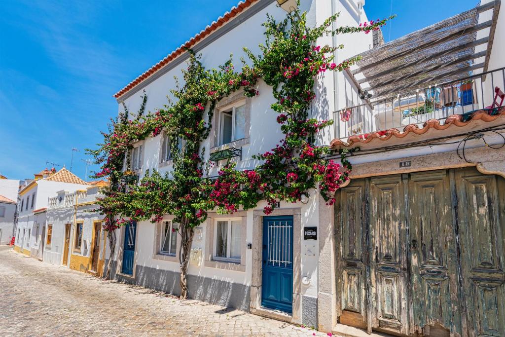 a street with flowers on the side of a building at Casa do Postigo in Tavira