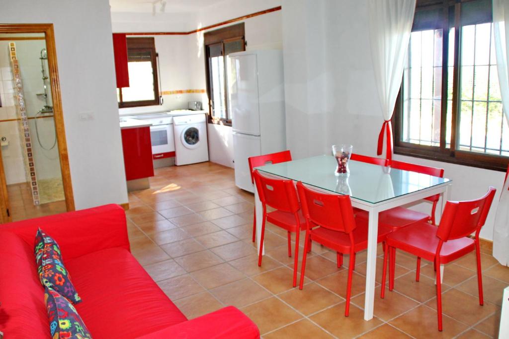 a living room with a red couch and a table and chairs at Apartamento Playa Bolonia in Bolonia
