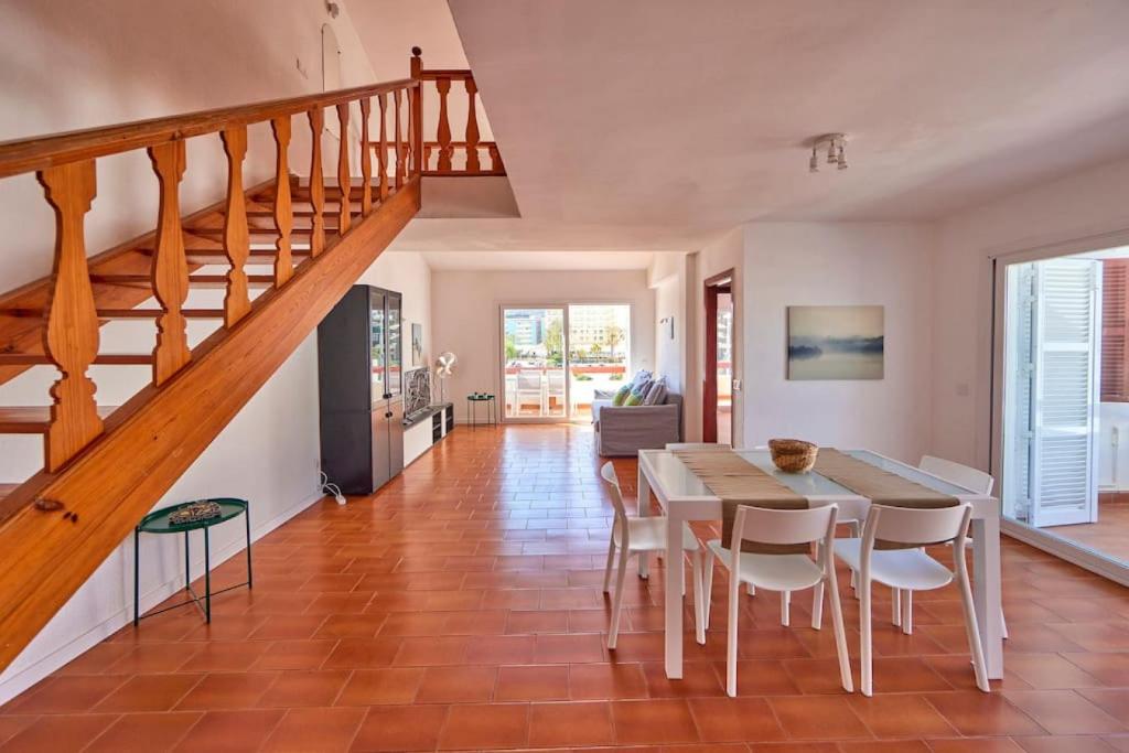 une salle à manger avec une table, des chaises et un escalier dans l'établissement Nura Houses Duplex Magaluf 5, à Magaluf