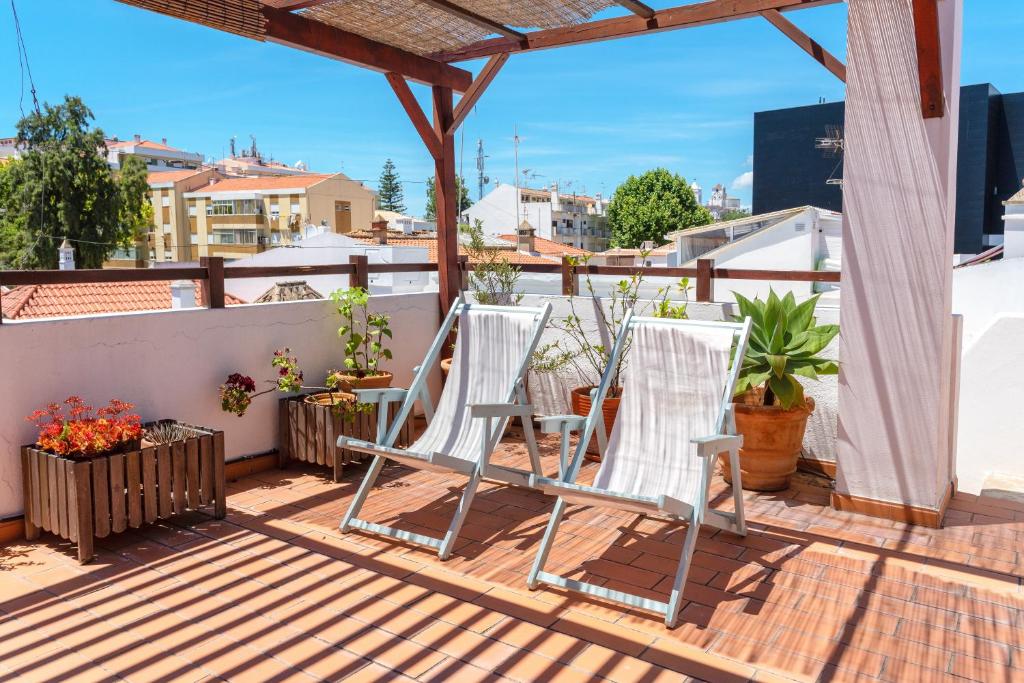 タヴィラにあるCasas da Formosa - Downtown Alegria B&Bのバルコニーに座る椅子
