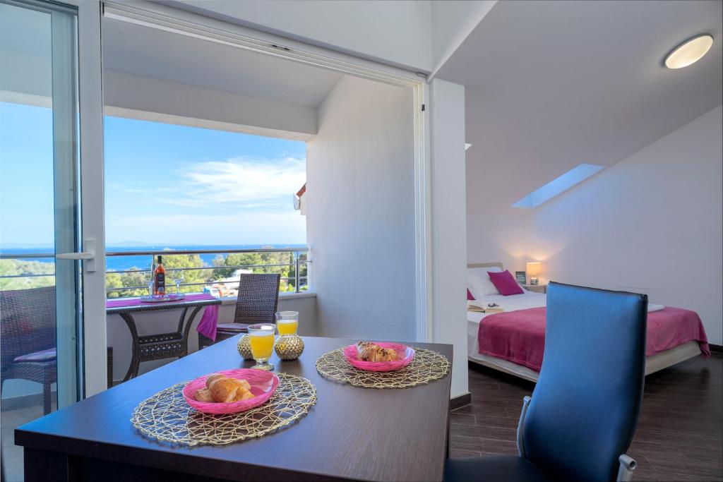 a room with a table with two plates of food on it at Villa Fio - Rooms & Studio in Hvar