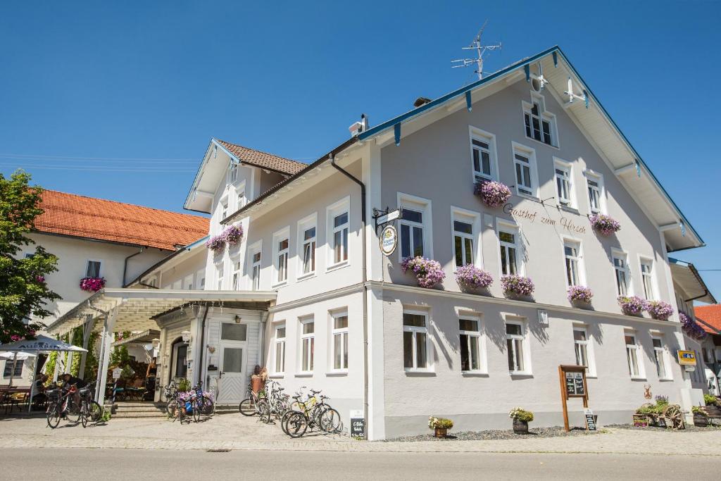ein weißes Gebäude mit Fahrrädern, die draußen geparkt sind in der Unterkunft Gasthof zum Hirsch in Görisried