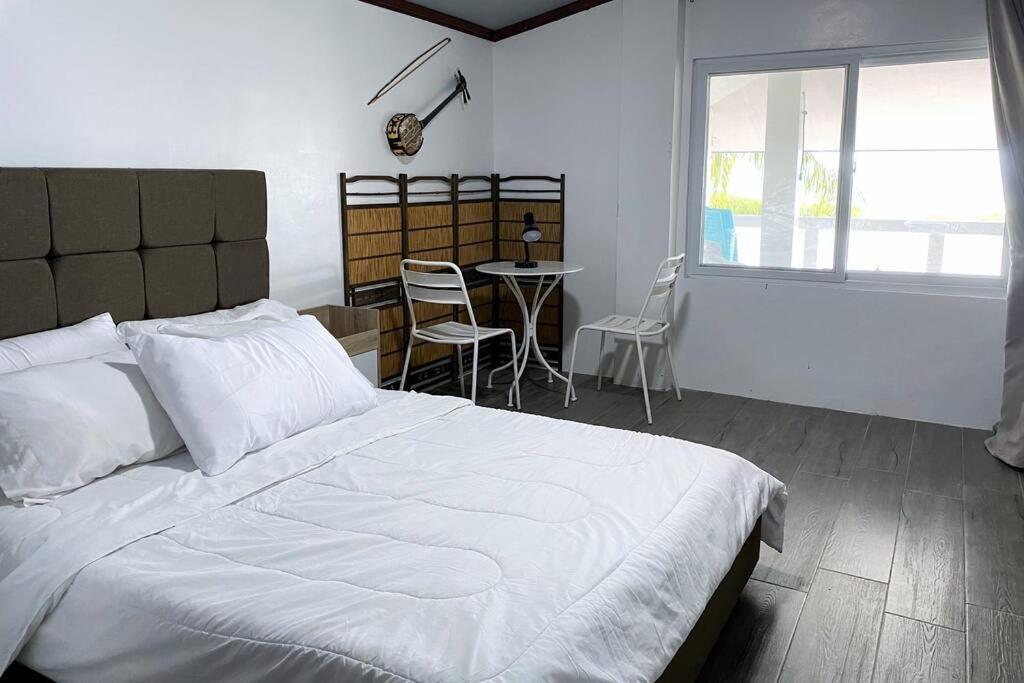 Schlafzimmer mit einem Bett, einem Tisch und Stühlen in der Unterkunft Toliz Beach House -Sipaway Island San Carlos City in San Juan