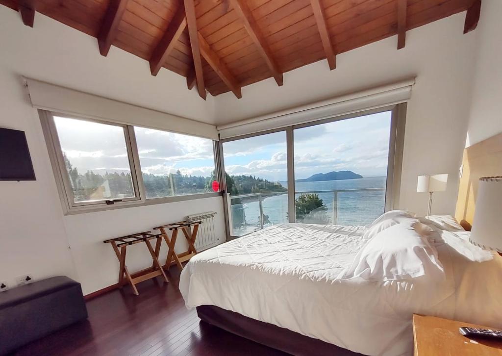 a bedroom with a large bed with a view of the water at Quinta Luna NH in San Carlos de Bariloche