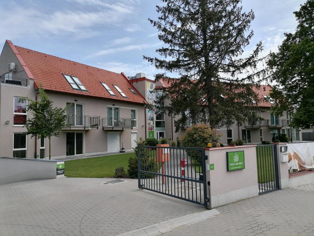 a building with a gate in front of a yard at Kapitány apartman in Siófok