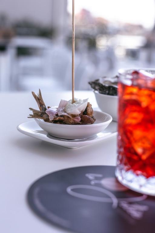 a plate of food on a table with a drink at Mosella Suite Hotel in Sottomarina