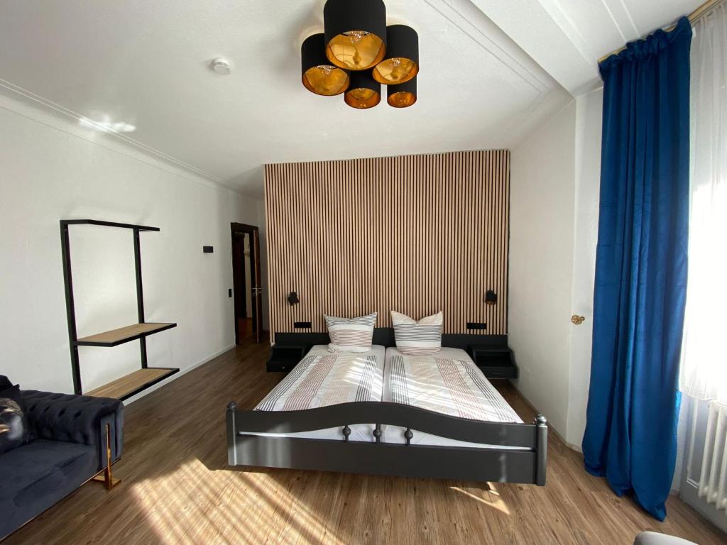 a bedroom with a bed and a blue curtain at Parkhotel in Rottweil