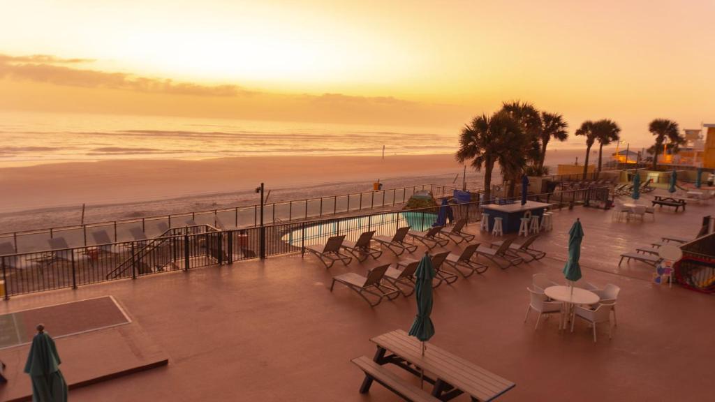 a view of a beach with chairs and tables at Tropic Sun Towers by Capital Vacations in Ormond Beach
