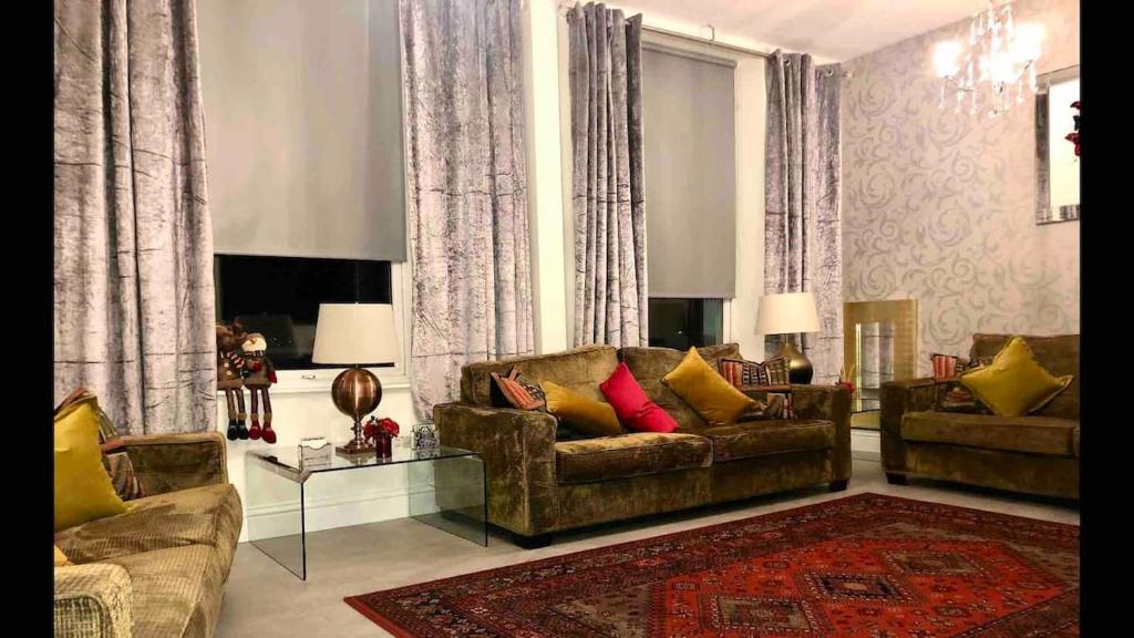 a living room with two couches and a rug at Ten Streets Apartment in Liverpool