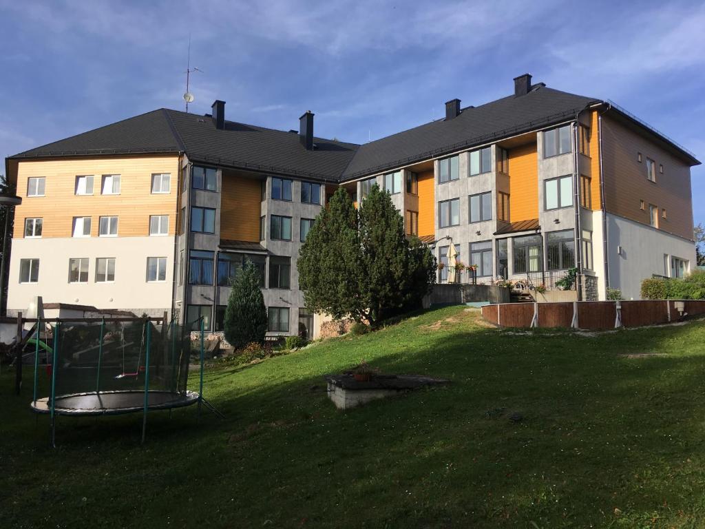 un grande edificio con parco giochi di fronte di EA Hotel Lipno a Černá v Pošumaví