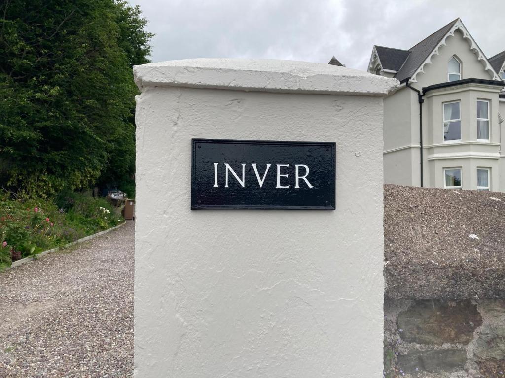 a sign on a white wall in front of a house at Inver in Cobh