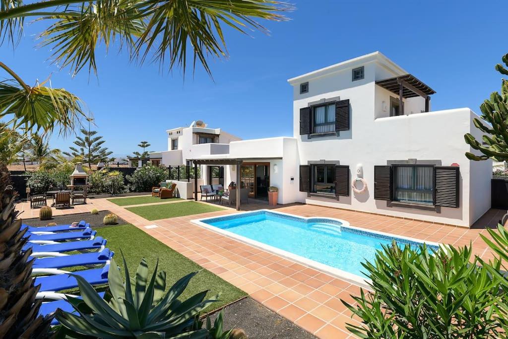 eine Villa mit einem Pool vor einem Haus in der Unterkunft Hipoclub Villas, Aguamarina 10 in Playa Blanca