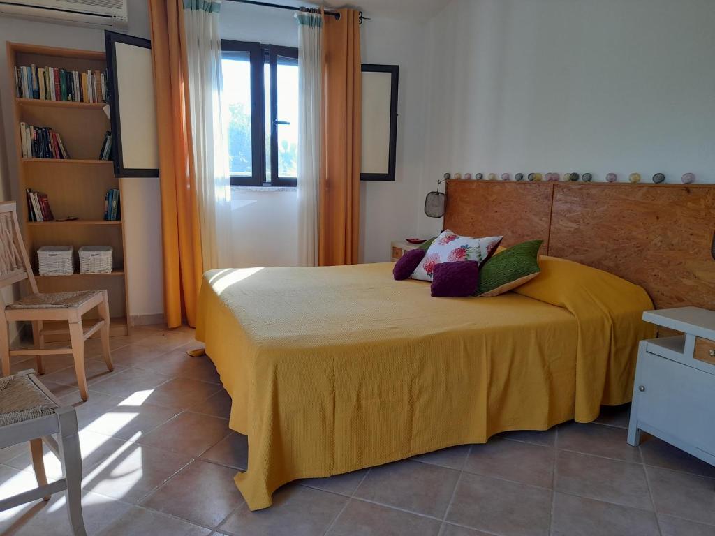 - une chambre avec un lit et une couverture jaune dans l'établissement La ReStanza, à Pula