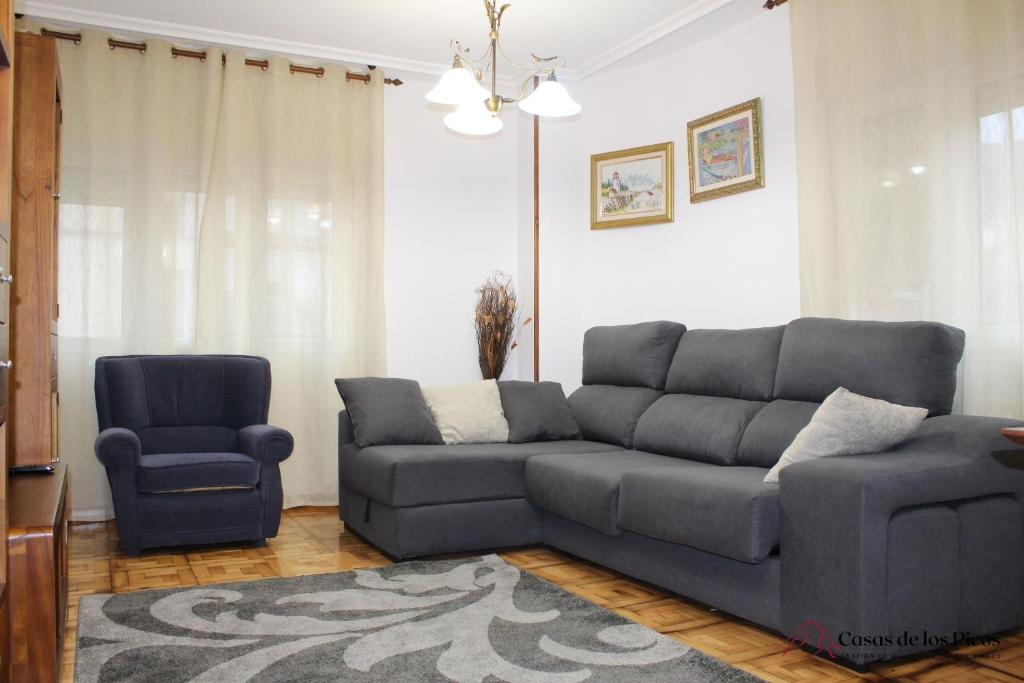 sala de estar con sofá y silla en VUT La Fuentina -Casas de los Picos, en Panes