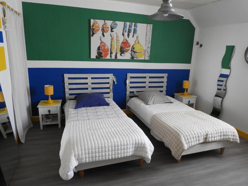 two beds sitting next to each other in a room at les volets bleus in Saint-Guénolé
