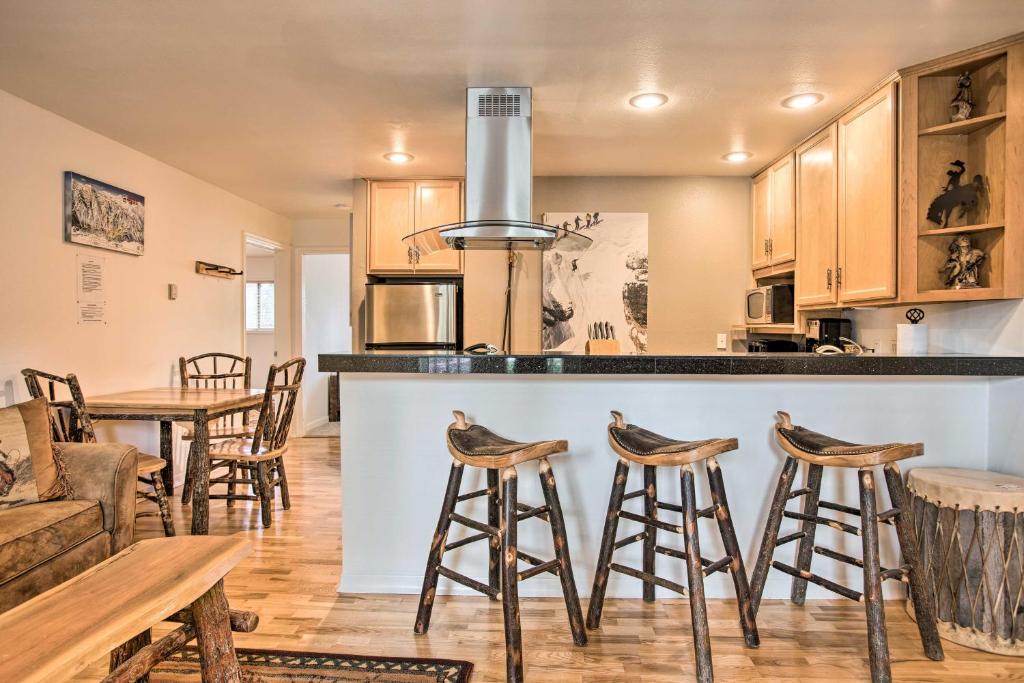a kitchen with a bar with stools and a table at Skiers Dream Upscale Condo By Teton Village! in Wilson