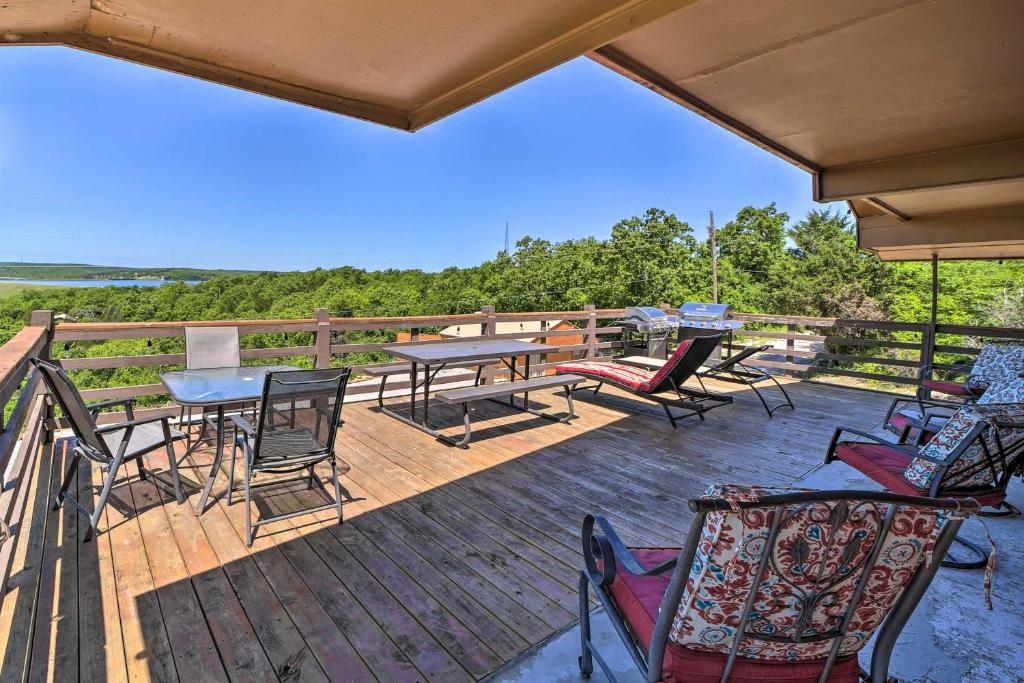 une terrasse en bois avec des chaises et des tables. dans l'établissement Vian Getaway with Lake Tenkiller Views and Deck!, à Gore