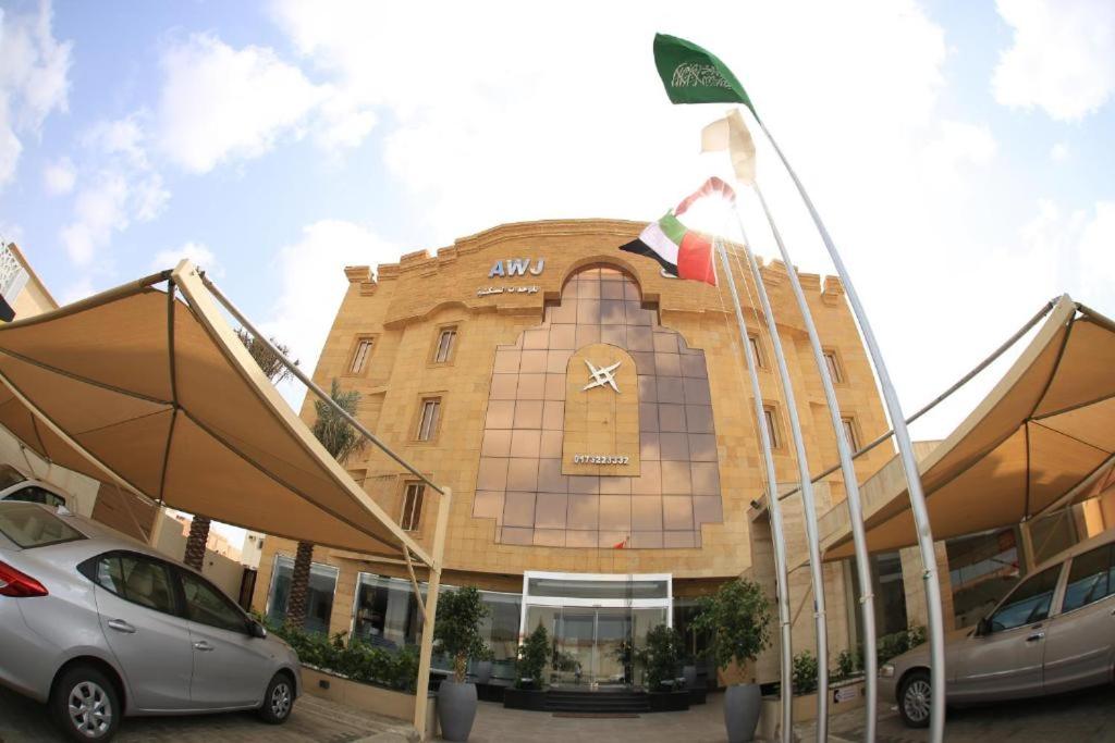 un edificio con auto parcheggiate di fronte di Awj Jazan Suites Hotels a Jazan