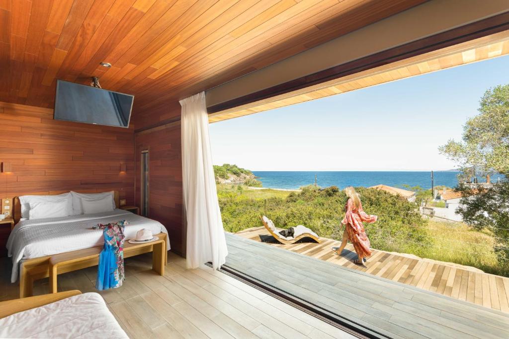 a bedroom with a bed and a view of the ocean at iHouse Paliouri in Paliouri