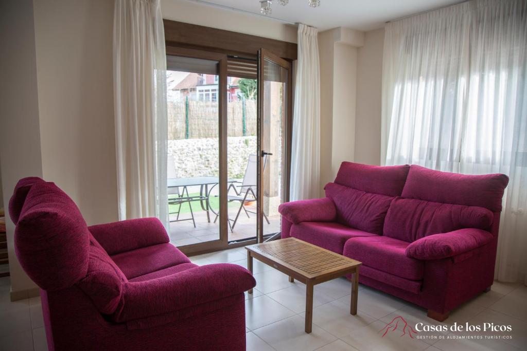 uma sala de estar com duas cadeiras e um sofá roxo em Chalet vacacional Tina Menor - Casas de los Picos em Pesués