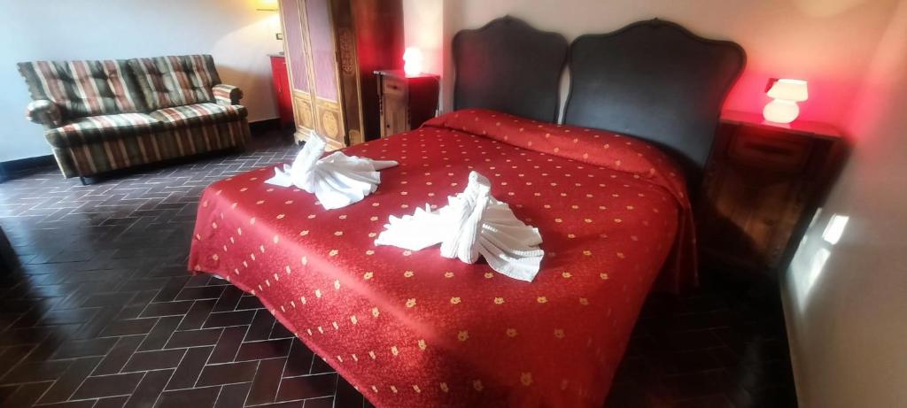 una camera con letto rosso e lenzuola bianche di VECCHIO MULINO FONTONA Ortensia a Chiesanuova