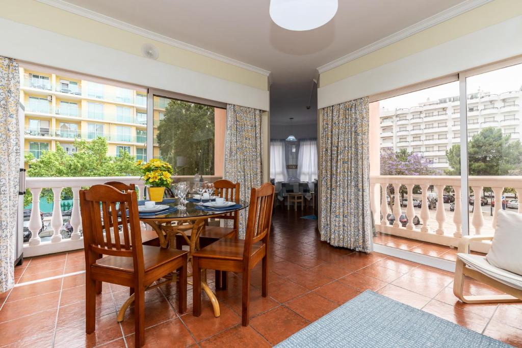ein Esszimmer mit einem Tisch und Stühlen sowie einem Balkon in der Unterkunft Parque dos Reis Apartment 2 in Monte Gordo