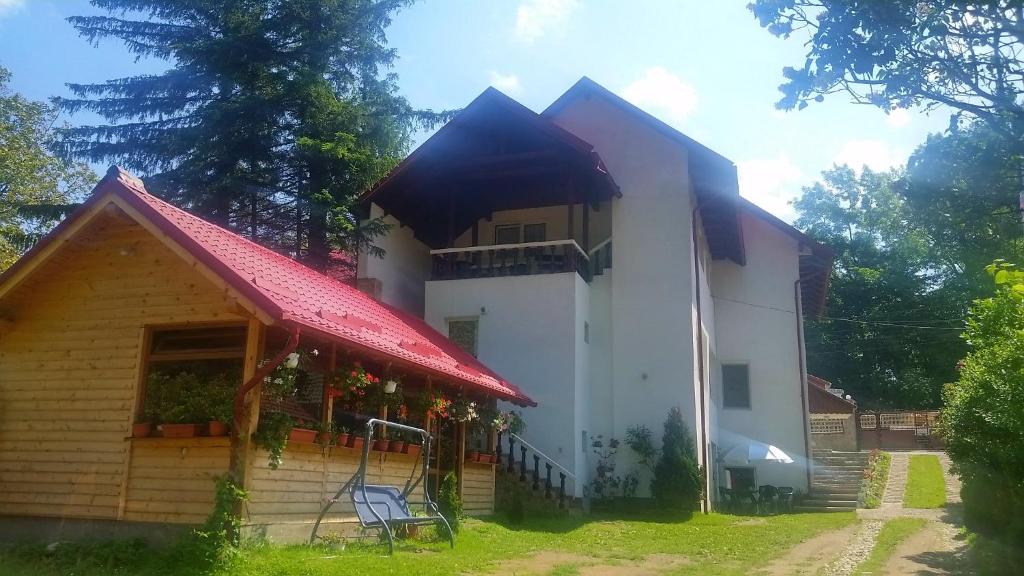 een groot wit huis met een rood dak bij Casa Krista in Bran