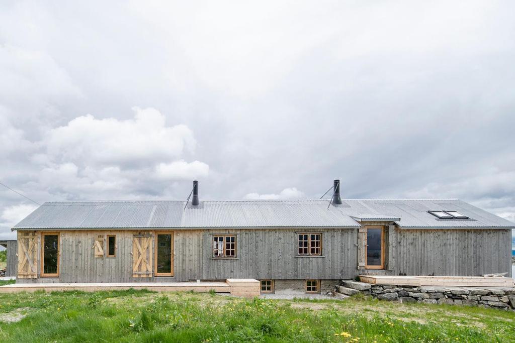 a house with a metal roof on top of a field at Sigurdbua in Kvalnes