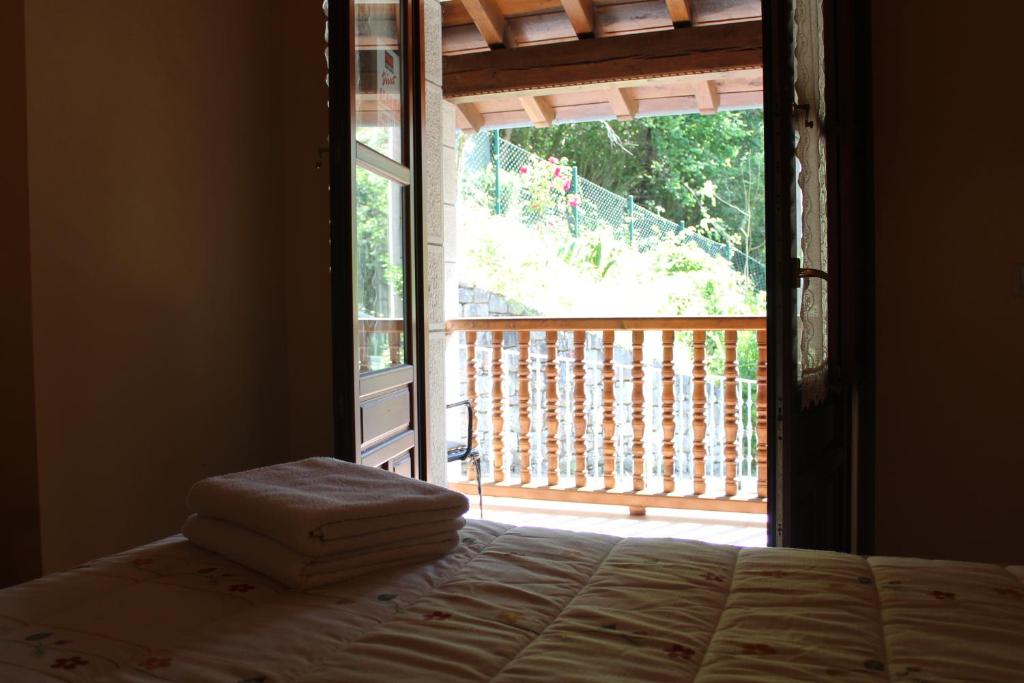 - une chambre avec un lit et une grande fenêtre dans l'établissement Vivienda vacacional La Güera - Casas de los Picos, à San Esteban