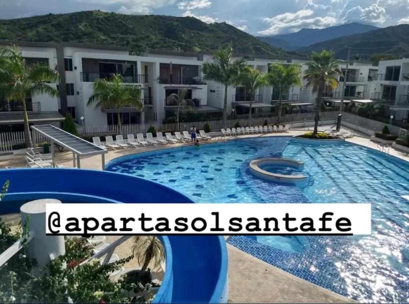 um resort com uma grande piscina em frente a um edifício em Ciudadela Santa Fe em Santa Fe de Antioquia