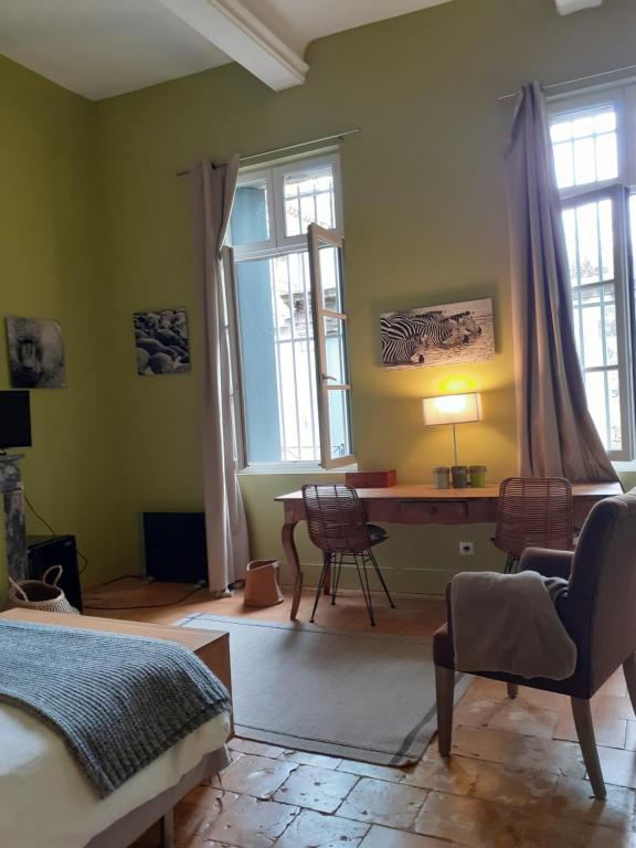 - une chambre avec un lit, un bureau et des fenêtres dans l'établissement Peyrou, studio la merci, 3 étoiles, à Montpellier