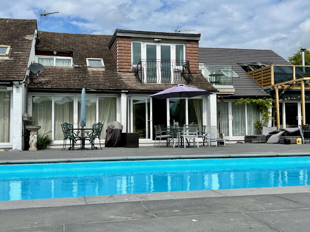 a house with a swimming pool in front of a house at The Kingfishers in Christchurch