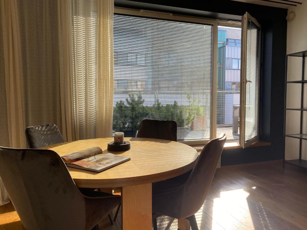 uma mesa de jantar com cadeiras e uma grande janela em Kaupmehe Terrace Apartment, free parking em Taline