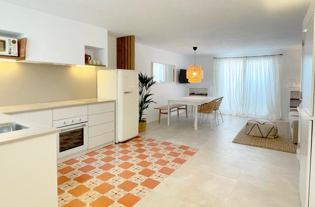 a kitchen and living room with a table and chairs at APARTAMENTOS LA PALMA FORNELLS in Fornells